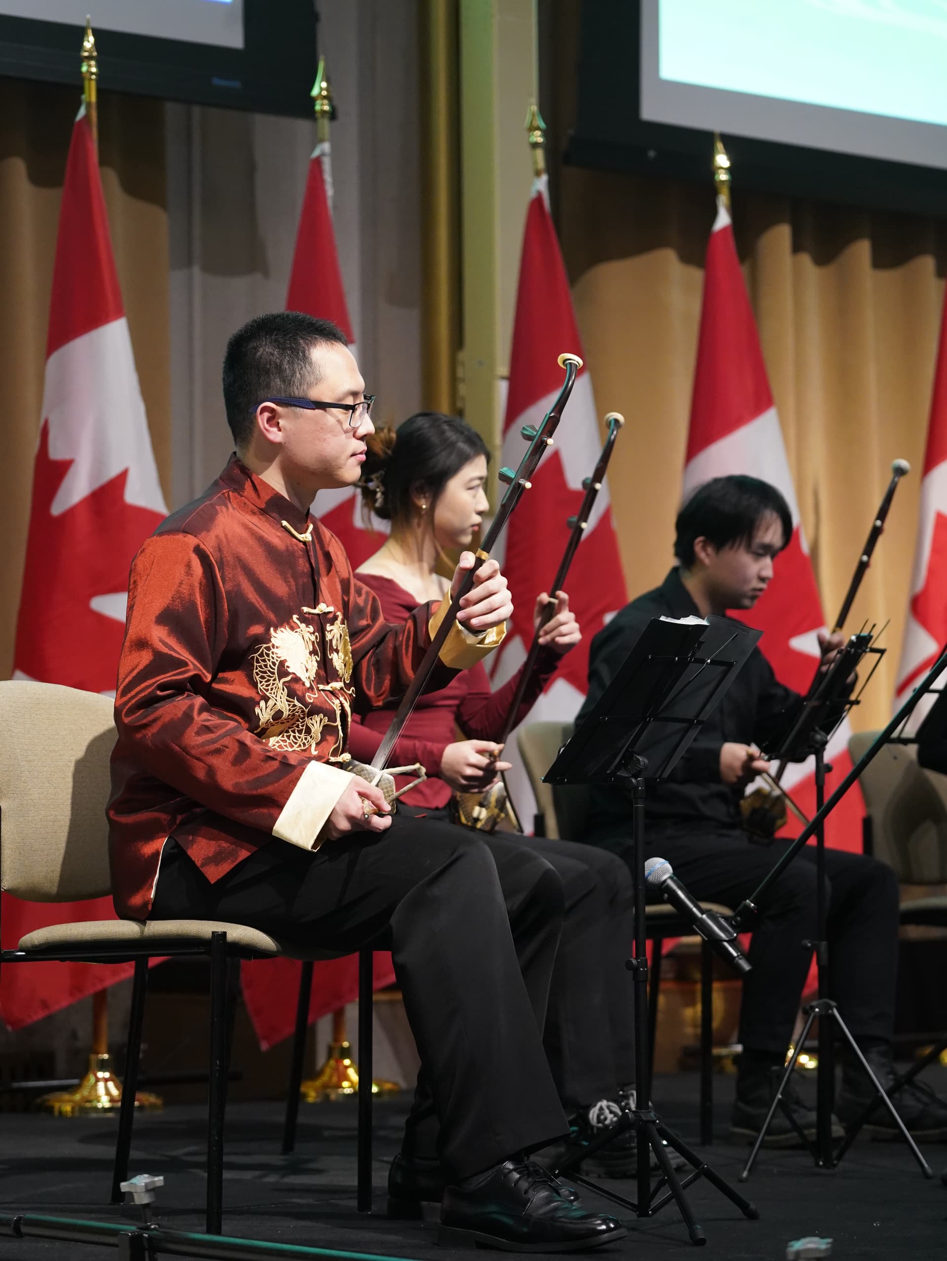 Members performing in front of Canadian flags at a reception